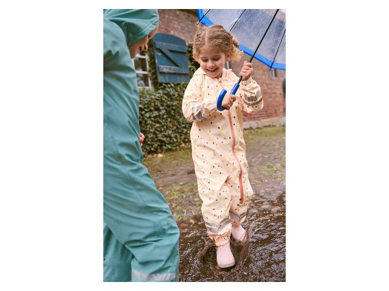 Kind in regenkleding springt in plas.