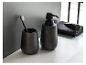 Zwarte keramische zeepdispenser en beker voor tandenborstel.