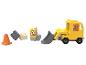 Een gele speelgoedgraafmachine met een figuur erbij, plus blokken, een kegel en een bord.