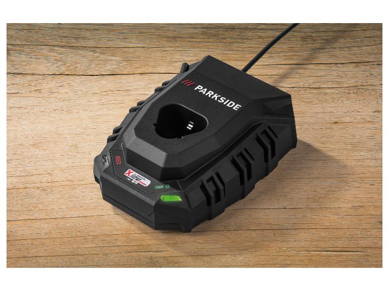 Zwarte acculader met een groen lichtindicator op een houten oppervlak.