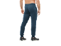 Man in donkerblauwe joggingbroek met boorden en zwarte sneakers.