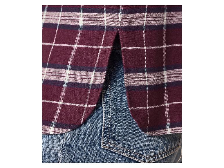 Bordeauxrood geruit overhemd met split aan de zoom, gedragen over jeans.