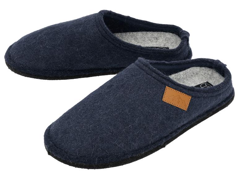 Een paar donkerblauwe vilten pantoffels met een lichtbruin leren detail.