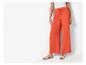 Lange oranje broek en platte sandalen: zomerse, casual look.