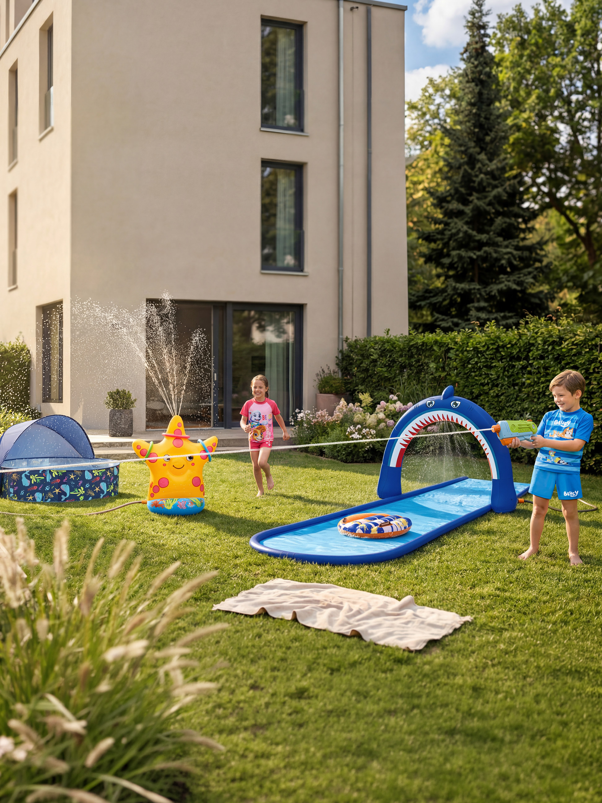 Kinderen spelen met een zeester-tuinsproeier en een haaienwaterglijbaan.