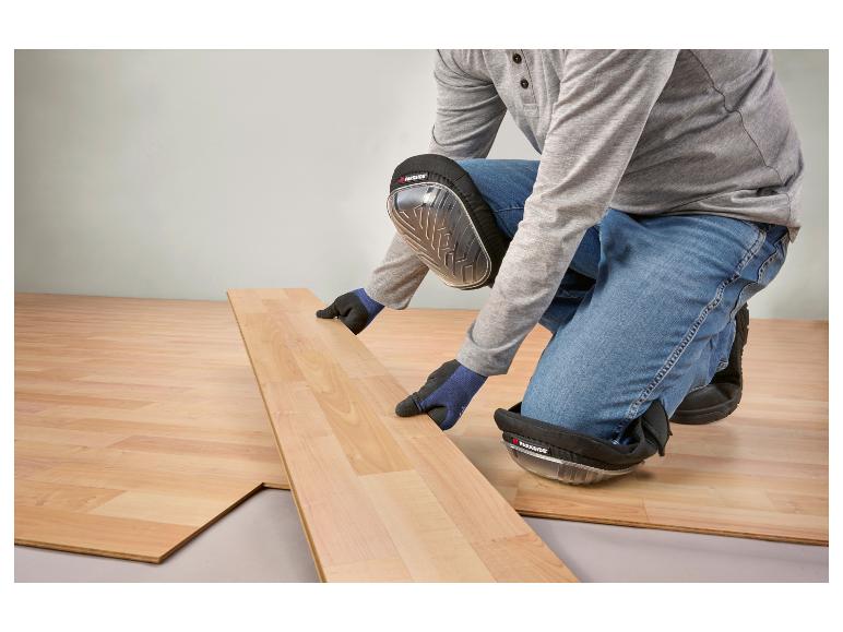 Persoon met Parkside kniebeschermers legt laminaatvloer.