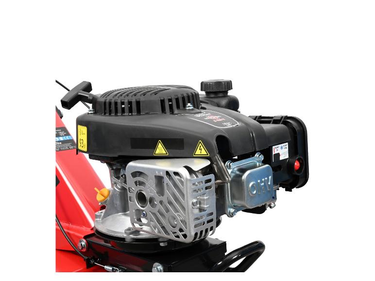 Close-up van een rode en zwarte gemotoriseerde cultivator met benzinemotor.