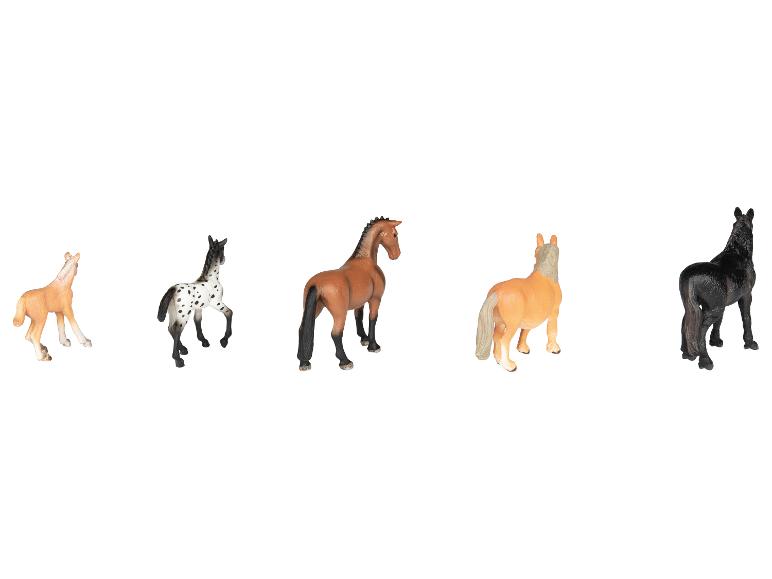 Vijf speelgoedpaardfiguren in verschillende kleuren en rassen, op een witte achtergrond