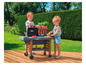 Twee kinderen spelen met een Smoby barbecue op een houten terras.