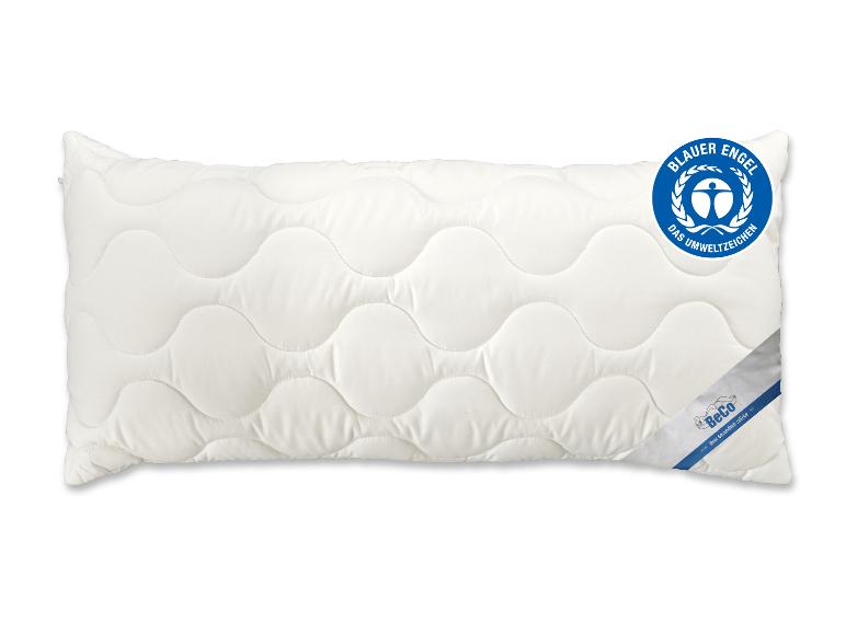 Wit kussen met golvende stiksels en een blauw milieukeurmerk.