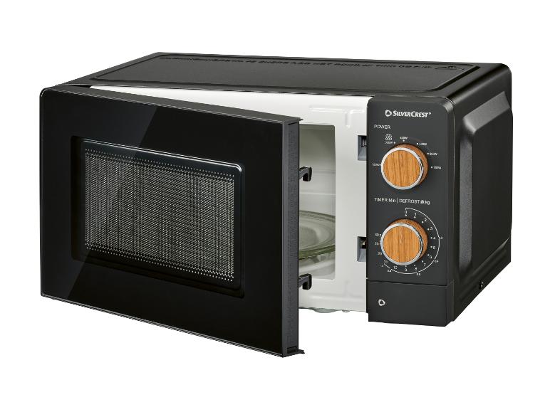 Zwarte magnetron met open deur en houten knoppen, met vermogens- en timerinstellingen.