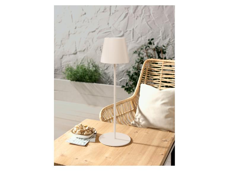 Moderne tafellamp en rotan stoel: gezellige sfeer.