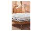 Wit matras met topper op een houten bed in een slaapkamer met roze muren.