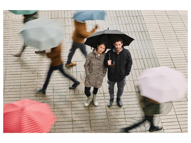 Koppel met Hunter laarzen en regenjassen in de regen.