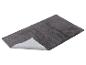 Grijze pluizige badmat met antislip onderkant, schuin weergegeven.