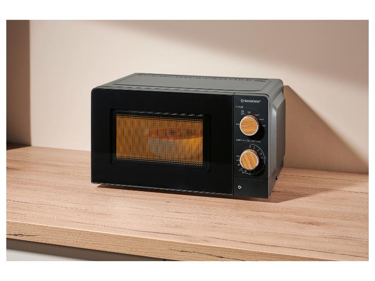 Zwarte magnetron met houten knoppen op een houten aanrecht.