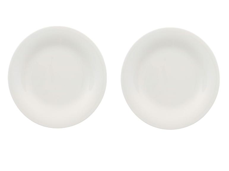 Twee witte keramische borden, naast elkaar geplaatst op een witte achtergrond.