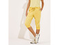 Gele capri-joggingbroek met witte sneakers.