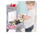 Kind speelt met een houten speelgoedbarbecueset en pluche eten.