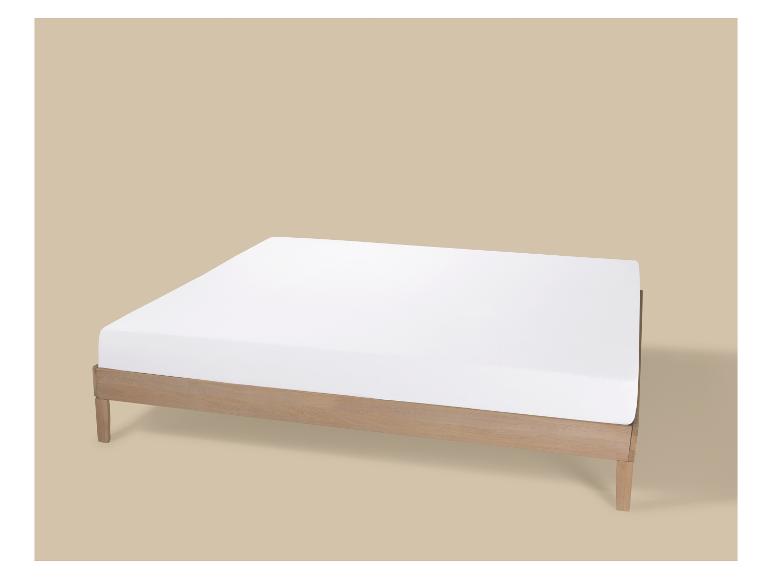 Houten bed met wit matras op beige achtergrond.