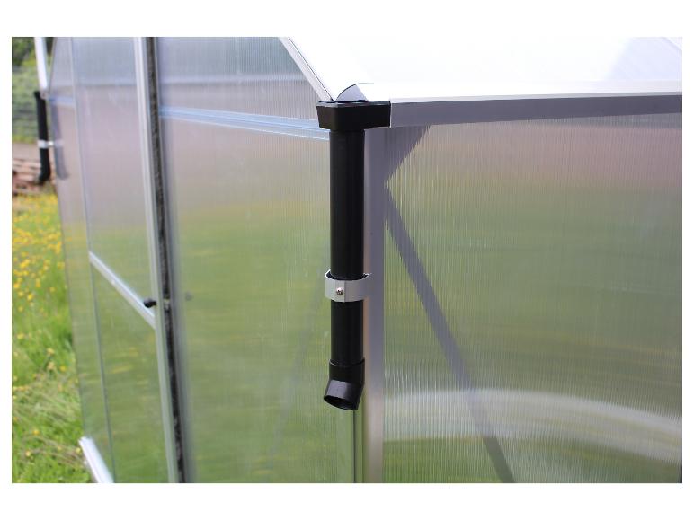 Een close-up van een transparante kas met een zwarte regenpijp.