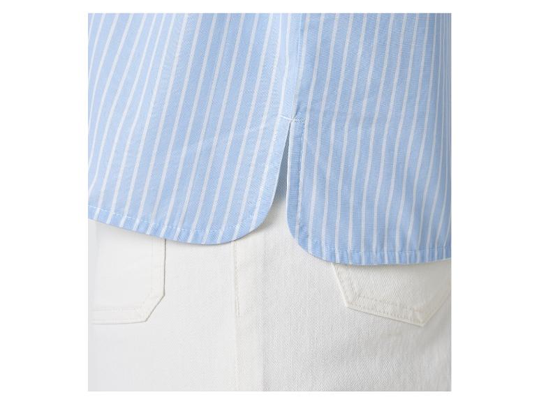 Lichtblauw gestreept overhemd en witte broek.