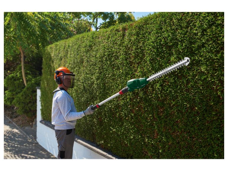 Man snoeit haag met Parkside telescopische heggenschaar.