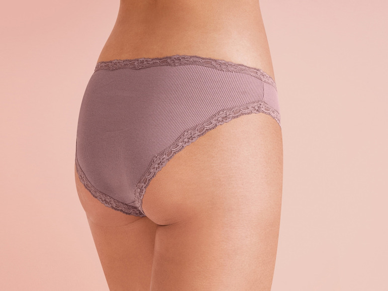 Een vrouw draagt ​​een roze onderbroek met kant.