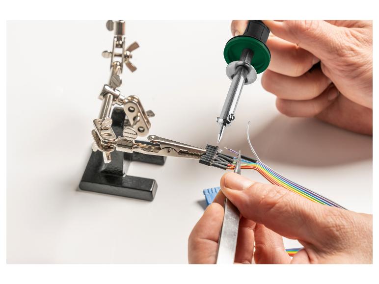 Een soldeerbout wordt gebruikt om draden te solderen met een rainbow-kleurig kabeltje.