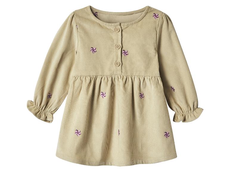 Beige corduroy babyjurk met paars bloemenborduurwerk en knopen.