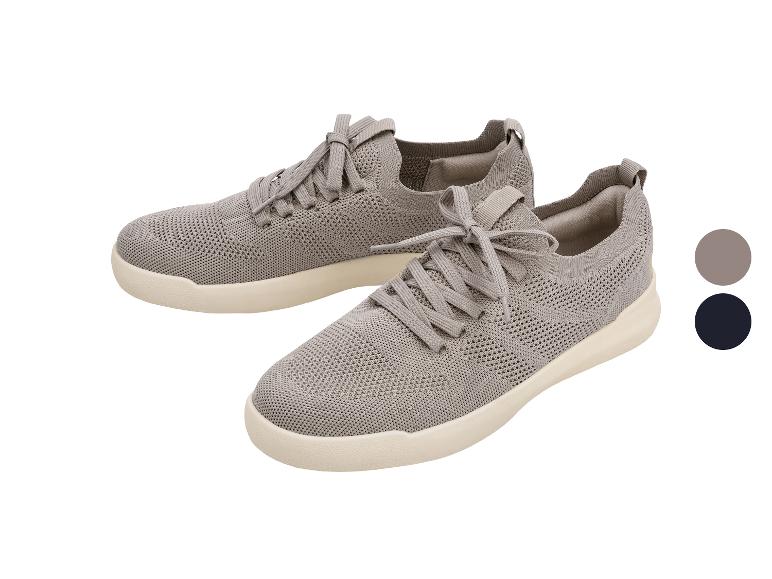 Een paar grijze gebreide sportschoenen met een beige zool en grijze veters.