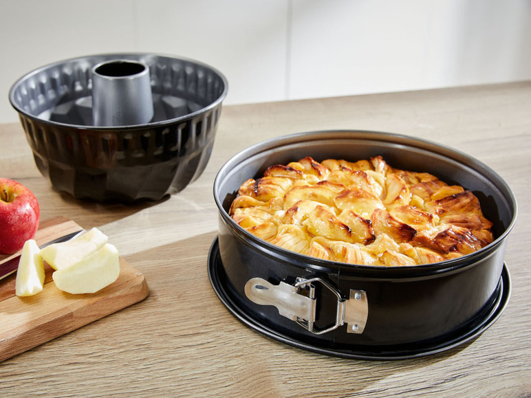 Een appeltaart in een springvorm met een bundtpan ernaast.