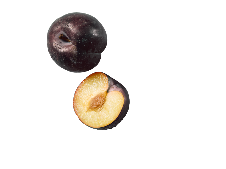 Hele pruim en halve pruim met geel vruchtvlees en pit, met waterdruppels.