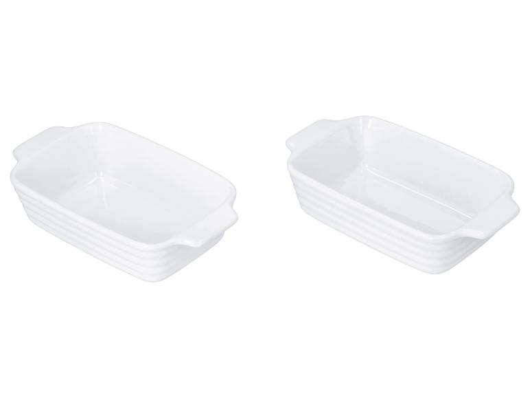 Twee witte keramische ovenschaaltjes met geribbelde zijkanten.