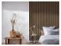 Slaapkamer met een bed, een houten hoofdeinde, een nachtkastje met een lamp en een decoratieve bank.