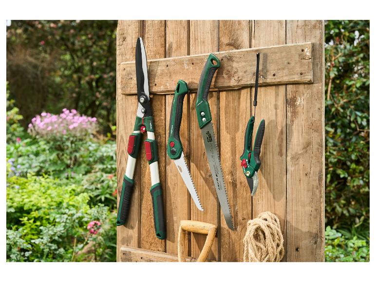PARKSIDE tuingereedschap, waaronder de 360° grasschaar, op een houten achtergrond.