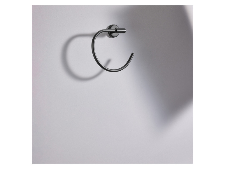Een zwarte handdoekring bevestigd aan een witte muur.