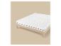 Houten bedframe met een wit matras en topper, op een beige achtergrond.