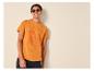 Man in oranje T-shirt met surfprint en zonnebril, lachend.