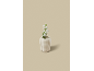 Een witte keramische vaas met een witte bloem op een beige achtergrond.