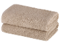Twee beige badhanddoeken, opgevouwen.