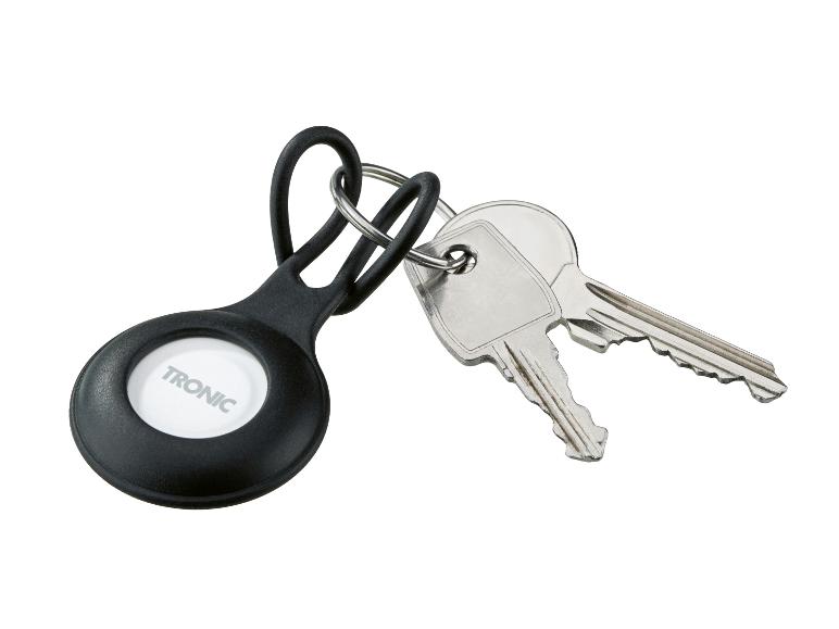 Zwarte sleutelhanger met witte knop en twee metalen sleutels.
