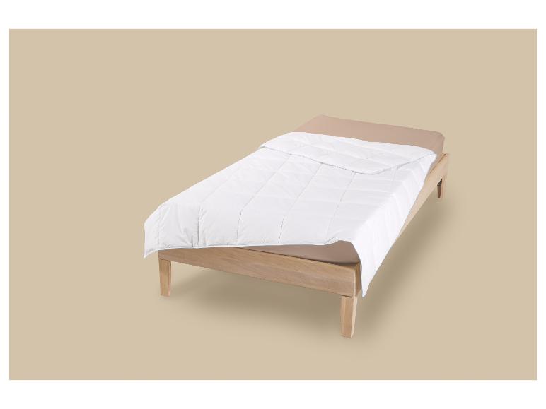 Houten eenpersoonsbed met beige matras en wit dekbed.