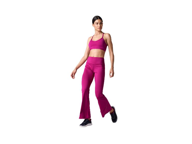 Vrouw in fuchsia sportbeha en flared broek