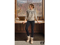 Vrouw in beige trui met patroon, zwarte legging en lichte winterlaarzen in een gezellige omgeving.