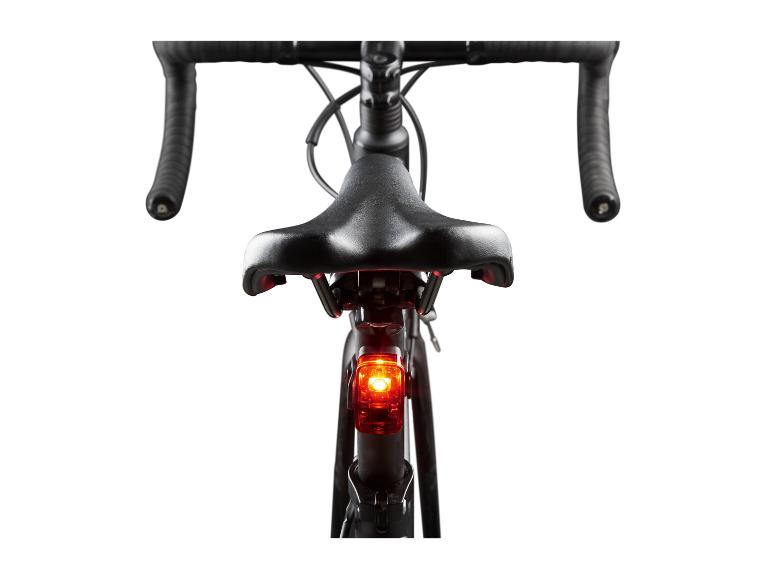 Een zwarte racefiets met een rood achterlicht.