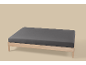 Houten bedframe met een donkergrijs hoeslaken op een lichte achtergrond.