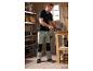 Man in PARKSIDE® werkbroek bewerkt hout in een werkplaats.