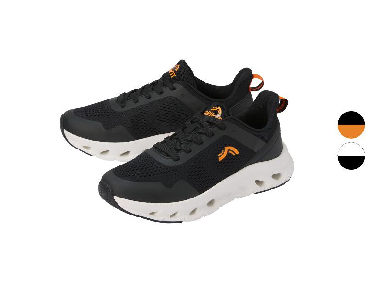 Een paar zwarte sportschoenen met oranje details en een witte zool.