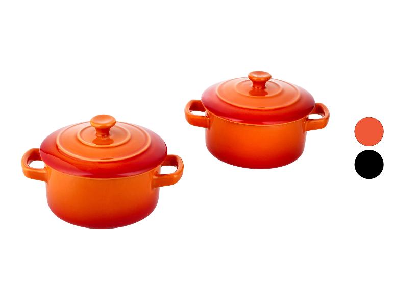 Twee oranje keramische minipannetjes met deksels, met kleurstalen rechts.